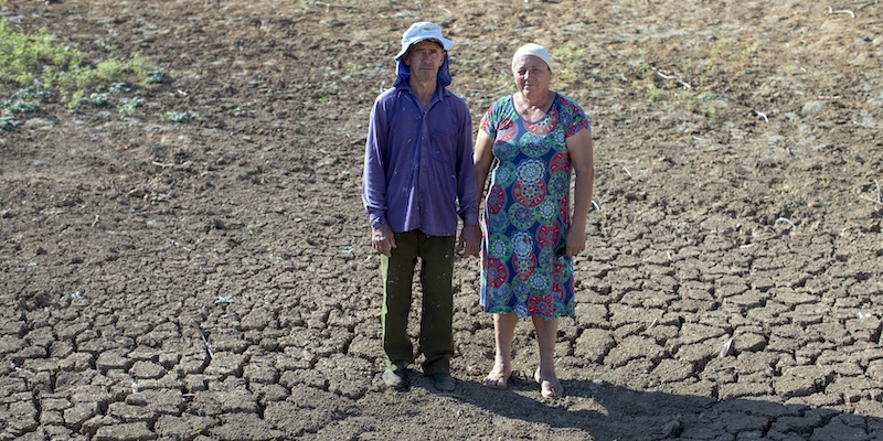 A man and a woman stand on dry land of the semi-arid region of Pernambuco, Brazil.
